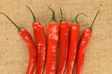 Red chili peppers, close-up, on jute fabric.