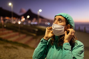 Caucasian woman putting on a protective mask against coronavirus