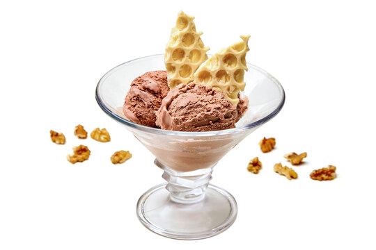 Homemade chocolate ice cream in a glass bowl with crushed white chocolate and walnuts