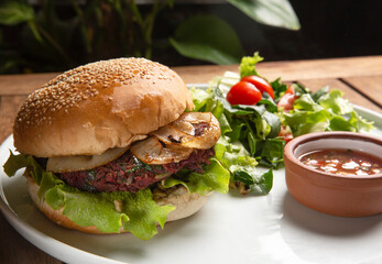 A Mexican bean veggie burger  menu served with green and dipping sauce. A close up view