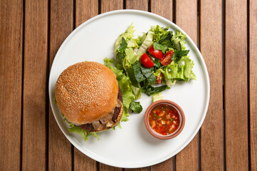A Mexican bean veggie burger  menu served with green and dipping sauce. Top view.