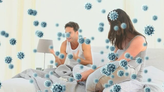 Digital composite video of Covid-19 cells moving against couple having a fight in bed in background
