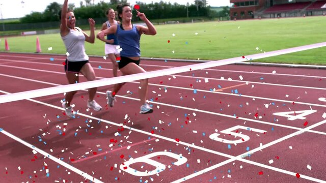 Digital composite video of multi colored confetti falling against three women finishing a race
