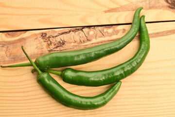 Green chili pepper in a cut, close-up, on a  wooden table.