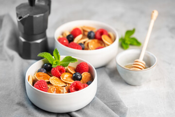 Tiny cereal small pancakes with blueberries, raspberries, mint and honey for a breakfast