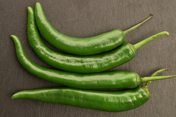 Green chili pepper, close-up, on a slate board.