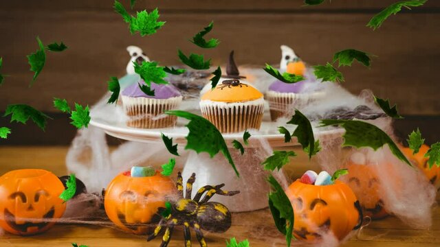 Digital Composite video of autumn leaves falling against Halloween cupcakes in background