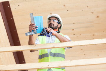 Junger Handwerker, Mann mit Helm, erstellt ein Holzgebäude