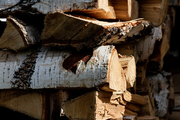 folded woodpile firewood outdoors in a village on a bright summer day