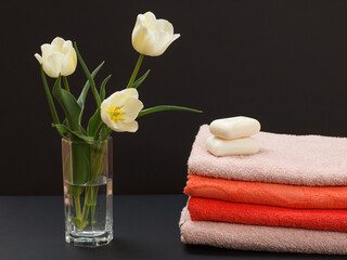 Obraz na płótnie Canvas Bouquet of yellow tulips in vase with towels on a black background.