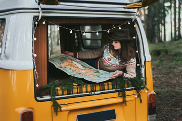 Traveler girl sitting in the retro car looking map. - obrazy, fototapety, plakaty