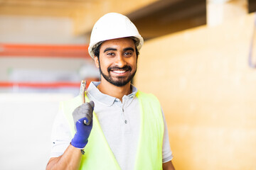 Junger Handwerker, Mann mit Helm, erstellt ein Holzgebäude