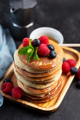 Pancakes with blueberries, raspberries, mint and honey for a breakfast