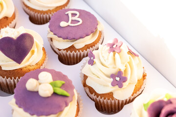 Obraz na płótnie Canvas Closeup of tasty homemade cupcakes with sugar icing in paper box.