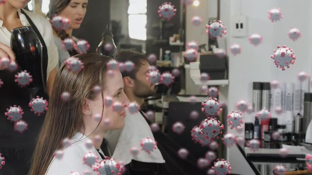 Animation of macro Covid-19 cells floating over Caucasian man and female sitting in a hairstyle salo