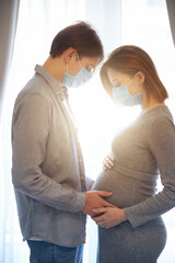 Fototapeta premium Sunny day at home of pregnant young couple in quarantine