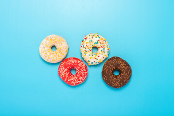 Donuts of different types on a blue background. Concept of sweets, bakery,. Banner. Flat lay, top view