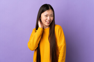 Young Chinese girl over isolated purple background laughing