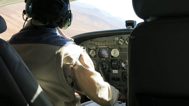 Pilot in einer Cessna (Kleinflugzeug) vor seinen Cockpitinstrumenten