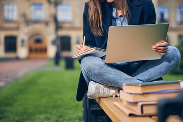 Female in casual clothes spending time outdoors and studying