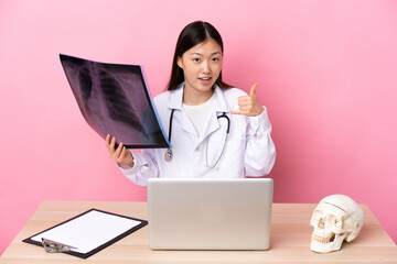 Professional Chinese traumatologist in workplace making phone gesture