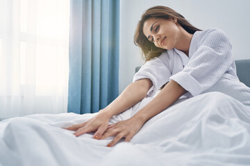 Charming young woman resting in bed at home