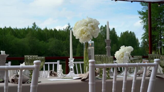 Beautiful wedding decor, all decorated in a white style. Chiavari chairs, candles in candlesticks, lake shore.