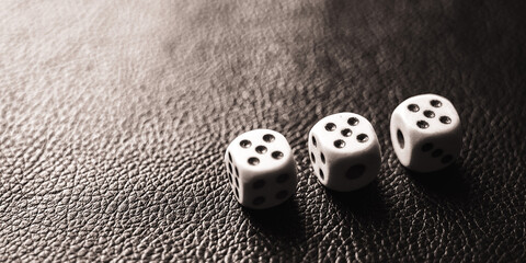 Three dices on the black table. BW photo