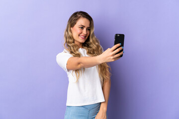 Fototapeta premium Young Brazilian woman isolated on purple background making a selfie