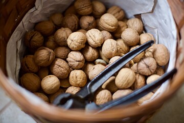 walnut crushing tool and shelled walnuts in the basket. Natural and organic village walnuts. There is also some shelled almonds in the basket. 