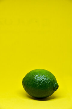 green lime with shadow, on yellow background