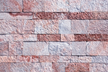 Background, texture laying of natural stone in a light red hue.