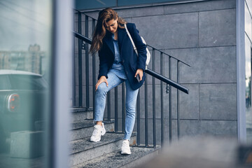 Beautiful lady with dark hair feeling pain outdoors