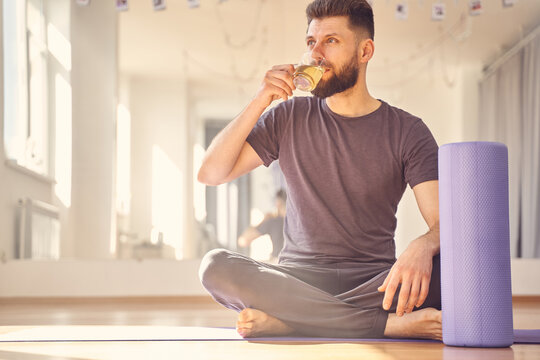 Handsome Young Man Drinking Tea In Yoga Studio