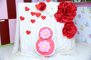 Red hearts . White curtain . Red roses made of paper . March 8 background. Red and white golden flowers.