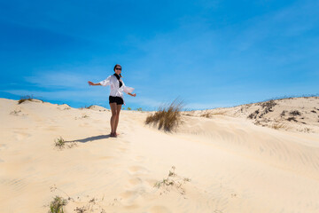 Fototapeta na wymiar Happy woman on White sand dunes in Vietnam