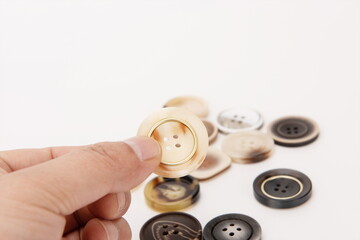 One hand picked one up from a pile of buttons.