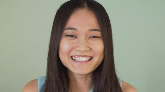 portrait close-up. cute asian girl looking at the camera and laughing joyfully 4K