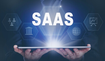 Fototapeta premium Businessman holding a computer tablet display projecting a SaaS concept.