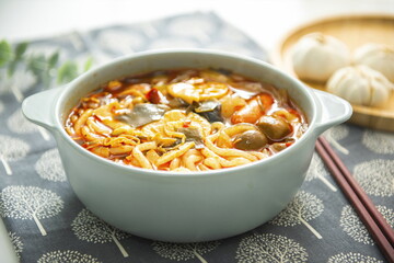 A bowl of spicy soup with noodles in it.