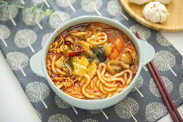 A bowl of spicy soup with noodles in it.