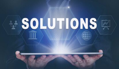 Businessman holding a computer tablet display projecting a Solutions concept.