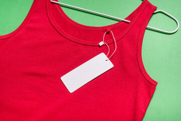 Red T-shirt on the straps on hanger with carton tag label