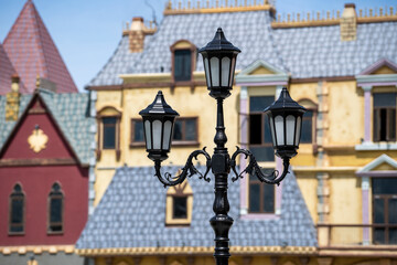 Street lamppost against the old buildings background. Classic victorian street lamps on an old fashioned iron lamp post set