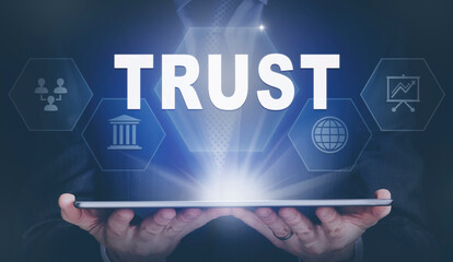 Businessman holding a computer tablet display projecting a Trust concept.