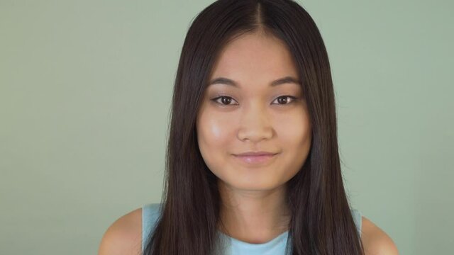 portrait close-up. cute asian girl looking at the camera and smiling 4K