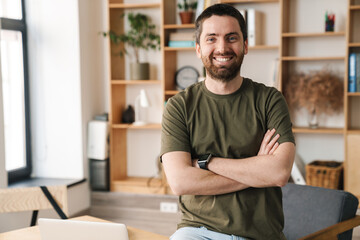 Fototapeta premium Photo of cheerful handsome man smiling and looking at camera