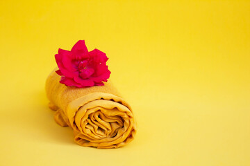 Autumn background. Yellow scarf, red rose on a yellow background. Copy of the space.