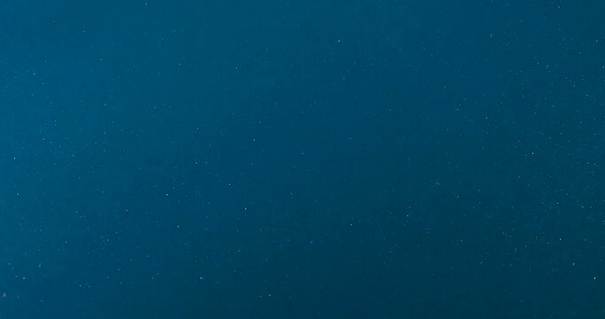 slow motion crystal particles on blue background