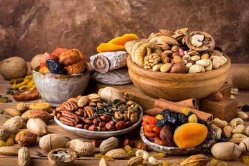 Composition from mix of dried fruits and nuts - symbols of judaic holiday Tu Bishvat. Brown background, space for text